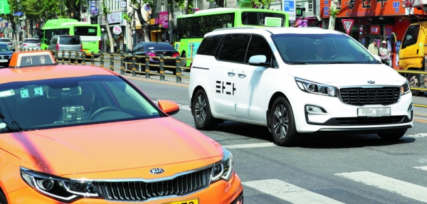 ▲타다 차량이 택시를 지나가고 있다(출처: 한겨레신문)